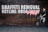 a brick wall with a graffiti of a man holding a paint can