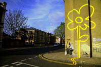 a yellow flower painted on the side of a building