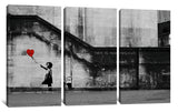 a black and white photo of a girl holding a red balloon