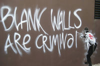 a man spray painting graffiti on a wall
